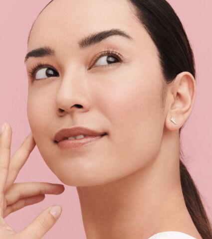 Woman with freshly cleansed skin with head turned looking off into the distance.