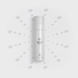 Tri-Phasic Bright Cleanser tube lying over a star pattern of pearls.