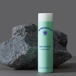 nu-skin-nutricentials-here-you-glow-exfoliating-toner-product-rock-background