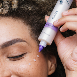 A woman applying a few drops of Nutricentials Bakuchiol Pumps Serum on the skin around her eye.