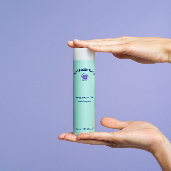 nu-skin-nutricentials-here-you-glow-exfoliating-toner-product-in-hands-lifestyle-image