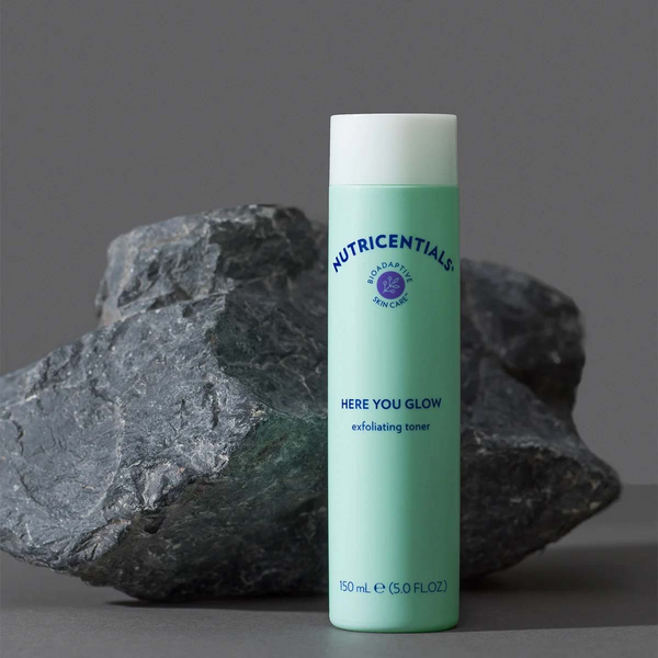 nu-skin-nutricentials-here-you-glow-exfoliating-toner-product-rock-background