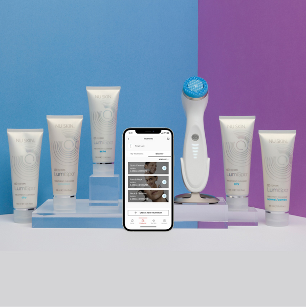 ageLOC Lumispa io device standing next to its cleansers collection and a phone logged into the Vera app. 